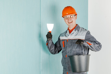 Repair advertising concept. Builder, plasterer, repairman, foreman in a helmet. A person with a...