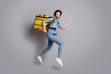 Fototapeta na wymiar Full body photo positive girl courier jump run want fast deliver meal lunch coronavirus quarantine carry thermal container wear denim jeans shirt helmet isolated gray color background