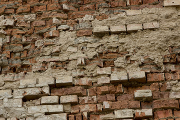 Fototapeta na wymiar Old ruined crumbling red brown brick wall