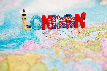 Travel and educational concept. Tourist attractions and souvenir of London on world map background of puzzles for travelers. Copy space