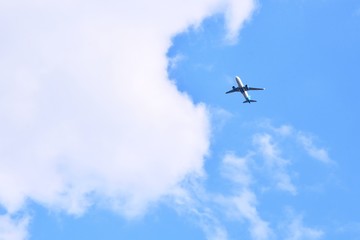 Kiev, Ukraine - May 2020. Airplane flying in the blue sky with white fluffy clouds. After pandemic future. Plane in the sky.
