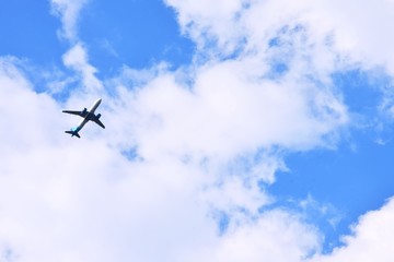 Kiev, Ukraine - May 2020. Airplane flying in the blue sky with white fluffy clouds. After pandemic future. Plane in the sky.
