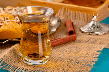 Turkish gllass cup of tea served with desserts on table