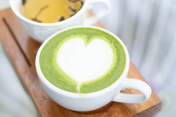 Closeup glass of matcha green tea shape on wood background with vintage color, selective focus