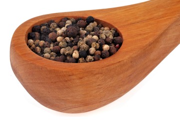 Cuillère en bois de poivre en grains en gros plan sur fond blanc
