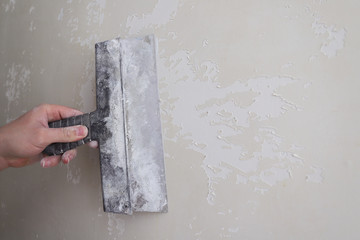 align the old walls with a finishing putty using a spatula