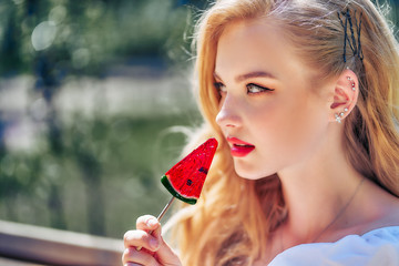 close-up portrait teenage girl with candy lollipop in the form of a watermelon slice