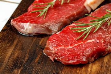 Barbecue veal steaks with rosemary on wooden board