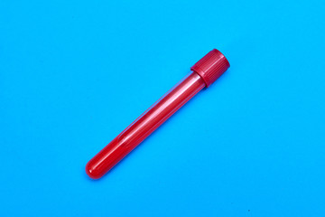 Test tube with blood on a blue background.