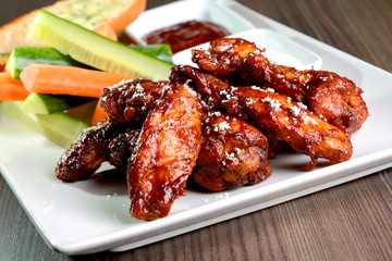 Grilled chicken drumsticks with fresh vegetables and white plate