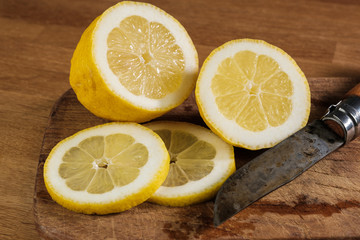 Zitronen, frisch aufgeschnitten auf einem Schneidebrettchen mit einem rustikalen Messer