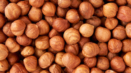 Background of raw peeled hazelnuts situated arbitrarily.