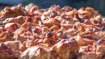 Fresh meat dressed on skewers is fried on a roaster or grill. The chef prepares meat in a cafe or restaurant. Fresh raw and fried pork, beef and lamb meat on a skewer. We fry shish kebabs, barbecue