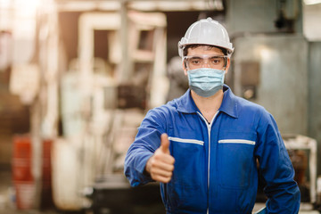 Fototapeta na wymiar Worker wearing face shield or disposable face mask during working service in factory to prevent Coronavirus(Covid-19) or Air dust pollution in factory.