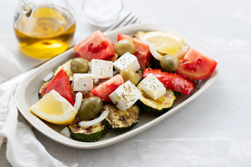 salad with fresh and grilled salad on white dish on gray ceramic background