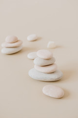 Fototapeta na wymiar Pale pastel stones stack on neutral stones. Flat lay, top view minimal spa concept.
