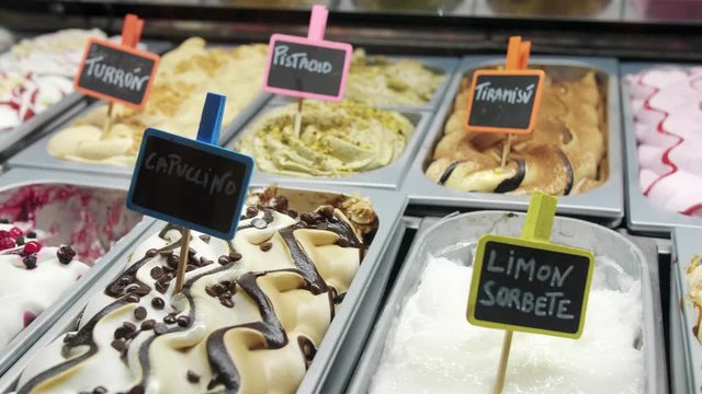 Traditional homemade gelato icecream tiramisu cappuccino pistachio limon turron delicious flavors in italy shop close up shot