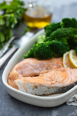 salmon with broccoli in dish on ceramic background
