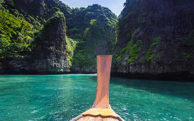 Thai traditional wooden longtail boat and beautiful sand Railay Beach in Krabi