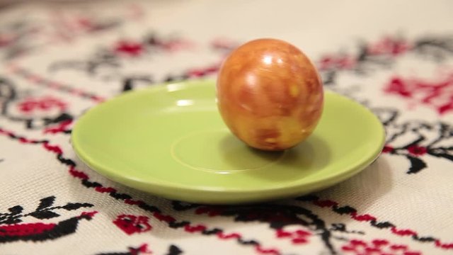 colored orange egg for Easter is spinning