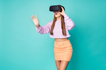 Photo of cool funky lady watch innovation game vr glasses open mouth unbelievable view wear cropped sweater naked belly orange mini skirt isolated teal color background