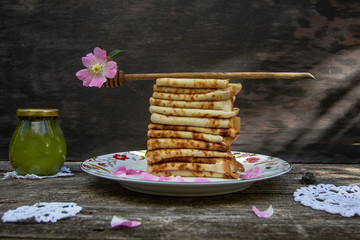 Delicious homemade thin pancakes on a beautiful plate. Russian kitchen