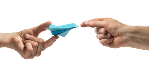 Person gives paper plane to another human. Concept of booking plane ticket, charters, tour....