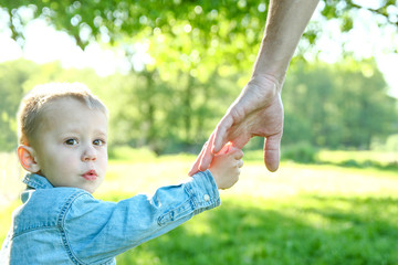 boy holds father's hand