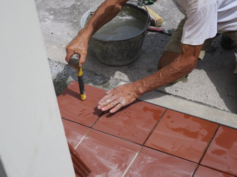 worker tiler metre laying tiles intent in his work