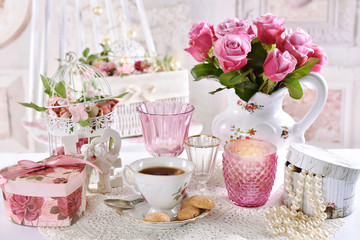 bouquet of pink roses in jug on the table with coffee and gift boxes