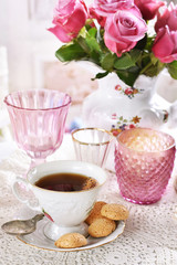 cup of coffee and italian cookies on the table with pink roses