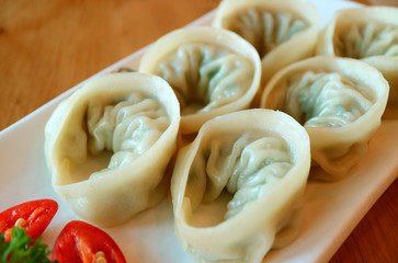 Closeup a Plate of Steamed Mandu or Korean Dumplings Served on Wooden Table