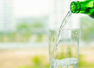 transparent glass of water with air bubbles green glass bottle