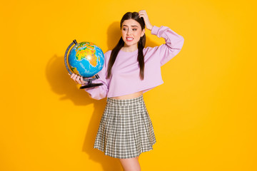 Fototapeta premium Portrait of frustrated school girl have geography lesson hold globe forget where europe located wear pullover style stylish trendy plaid clothes isolated over bright shine color background