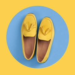 Top view of yellow woman's moccasins shoes in blue circle on yellow