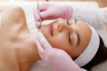 Young beautiful woman gets facial cleansing procedure in a beauty salon. Cosmetology.Cosmetic...