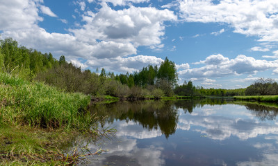 landscape with a beautiful river in spring, cloud reflections in the water