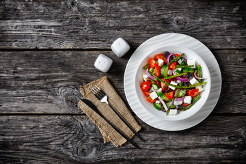 Greek salad with asparagus on a plate, copy space