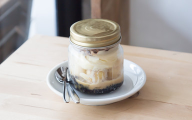 Delicious Banoffee in Mason jar on wood background