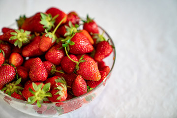 strawberry in a bowl of transparent glass. red ripe seasonal berries. 