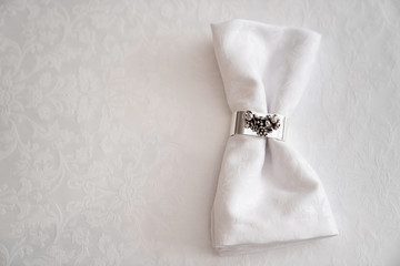 white cloth with a shiny metal pin. the festive table decoration. 