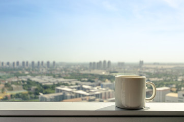 brake time with a ceramic mug of coffee and city view though window