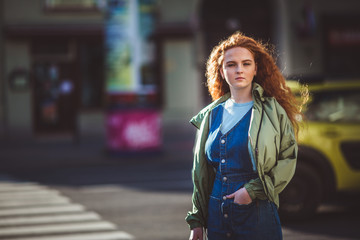 Portrait of redhead young pretty girl walking in the street of big city
