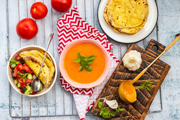 Orange pumpkin carrot creamy vegetables soup in bowl with rucola herb on top. Vegan food lunch