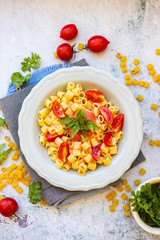 Cooked pasta tubes dish with red sauce, tomatoes and rucola herb spice. Vegan food lunch