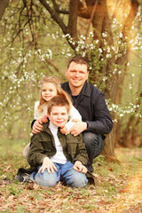 Father's day. Happy family concept. 
Caucasian father with children in the park laughing and having fun. The eldest son and the youngest daughter