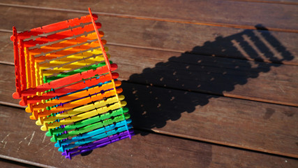 Tower and Shadow Made of Rainbow-colored wooden Stick on the table in the afternoon