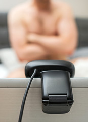 Man working as webcam model. Posing in front of camera.