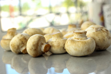 Fresh chestnut mushrooms on the table against the window background