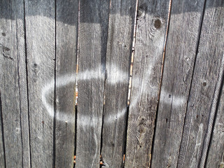 Old wooden fence with a pattern. Symbolic fish with white paint.     